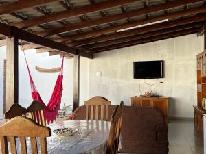 comedor con mesa y TV en Kasa Bastos, en Pirenópolis