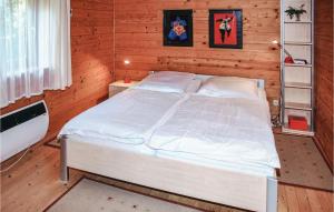 a bedroom with a white bed in a wooden room at Gorgeous Home In Schwarz With Kitchen in Schwarz