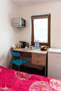a small kitchen with a desk and a microwave at Center Walking Apartment and Room in Bucharest