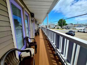 a porch with benches on a building with a view of a street at Regal Inn Hampton Beach in Hampton