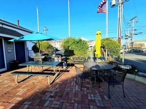 a group of tables with umbrellas on a brick patio at Regal Inn Hampton Beach in Hampton +3 photos