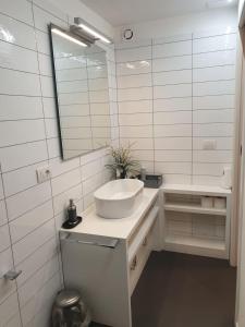 a white bathroom with a sink and a mirror at Napoli Belle Arti in Naples