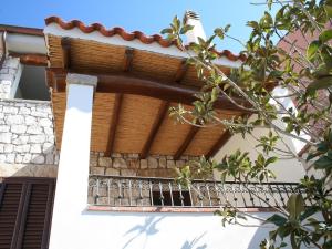 Villa Janas في بوناي: شرفة منزل مع سقف خشبي