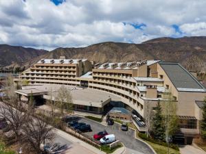 a large building with a parking lot in front of mountains at The Seasons Unit 205 in Avon