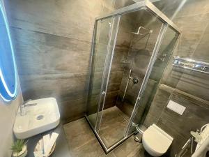 a bathroom with a shower and a toilet and a sink at ELMAR HOTEL in Vlorë