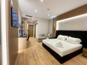 a bedroom with a large bed and a couch at ELMAR HOTEL in Vlorë