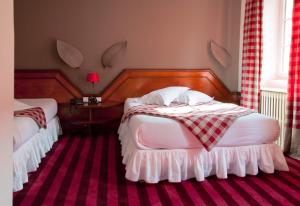 a bedroom with a white bedspread and a white dresser at Hotel Suisse in Strasbourg