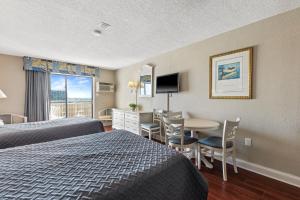 Habitación de hotel con 2 camas, mesa y sillas en Driftwood 51009, en Myrtle Beach