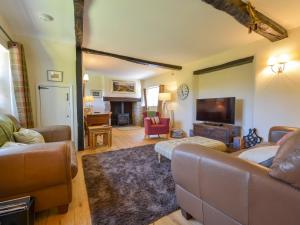 a living room with a couch and a flat screen tv at Michaelmas Cottage in Drewsteignton