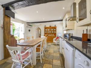 uma cozinha com uma mesa de madeira e cadeiras em Michaelmas Cottage em Drewsteignton