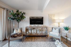 a living room with two chairs and a tv at Crossings at Watersound B102 in Inlet Beach