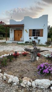 une petite maison blanche avec des fleurs devant elle dans l'établissement Azteca Villas, à Treasure Beach