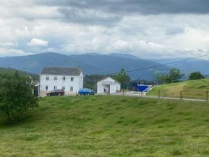 una casa bianca su una collina con un campo verde di Casa Darivas a Trabada