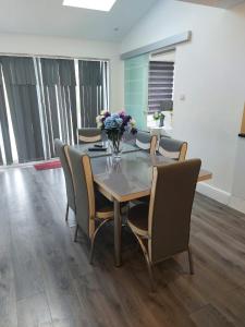 une table à manger avec des chaises et un vase de fleurs. dans l'établissement Modern Comfort House On Eamont RD, à Stockton-on-Tees