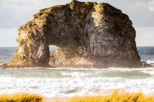 an arch in a rock in the ocean at Twin Rocks Haven in Rockaway Beach