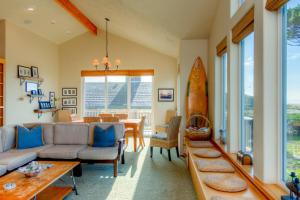 a living room with a couch and a table with a surfboard at Twin Rocks Haven in Rockaway Beach