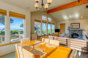 a dining room with a table and chairs and a fireplace at Twin Rocks Haven in Rockaway Beach
