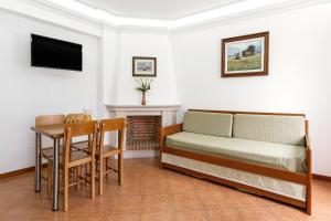 um quarto com uma cama e uma mesa e uma mesa e uma cadeira em Village Beach House em Nazaré