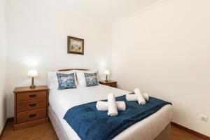 um quarto com uma cama com duas toalhas em Village Beach House em Nazaré