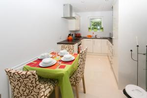 uma cozinha com uma mesa com uma toalha de mesa verde em So-Cosy Cityside em Belfast