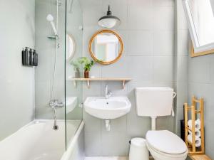 a bathroom with a toilet and a sink and a mirror at Mantur West Galilee by Selina in Loẖame HaGetaʼot