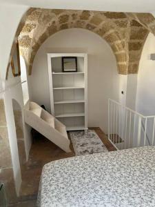 een kamer met een bed en een boekenplank bij Casa Mignano in Gallipoli