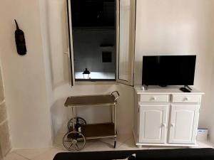 een kamer met een tv op een kast en een spiegel bij Casa Mignano in Gallipoli