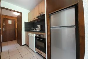 Il comprend une cuisine équipée d'un lave-vaisselle et d'un réfrigérateur. dans l'établissement Appartement sur les PISTES pour 6 à La Clusaz, à La Clusaz
