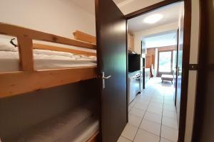 a bedroom with a bunk bed and a door to a room at Apartment on the slopes in La Clusaz
