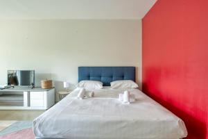 昂蒂布的住宿－Studio Rostagne - Welkeys，一间卧室设有一张红色墙壁的大床