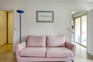 昂蒂布的住宿－Studio Rostagne - Welkeys，客厅里配有粉红色的沙发,配有台灯