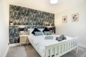 a bedroom with a large white bed with a wall at Stiniog Lodge in Blaenau-Ffestiniog