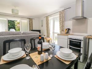 a kitchen and dining room with a table with a bottle of wine at Tranquillity in Liskeard