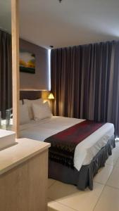 a bedroom with a bed in a room with curtains at Oceanami Resort & Beach Club in Long Hai