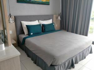 a bedroom with a large bed with blue pillows at Oceanami Resort & Beach Club in Long Hai +47 photos