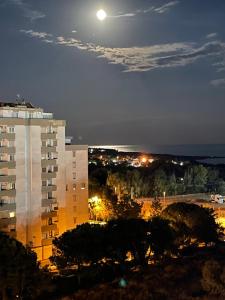 una vista de un edificio de noche con luna llena en B&b Miramare Taranto, en Taranto