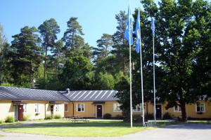 dos banderas en postes frente a un edificio en Ljungsbro Vandrarhem, en Ljungsbro