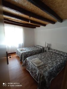 two beds in a room with a window at CASA RURAL EN RIAÑO-SOLORZANO in Santander