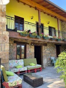 a patio of a house with a couch and a balcony at CASA RURAL EN RIAÑO-SOLORZANO in Santander