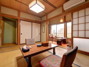 十日的住宿－瀨戶口旅館，一间客房内配有桌椅的房间