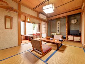a living room with a wooden table and a chair at Setoguchi in Tokamachi