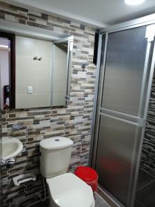 a bathroom with a toilet and a sink and a shower at Hotel Dubai Suite in Pasto