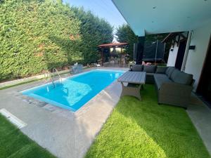 a swimming pool with a couch and a table in a yard at Evelina’s house in Neochorópoulon