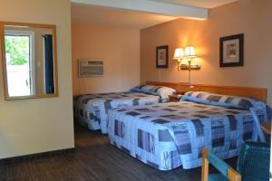 een hotelkamer met 2 bedden en een raam bij Bracebridge Inn in Bracebridge