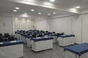 a room with rows of tables and chairs in it at Oft San Conrado Hotel in Goiânia