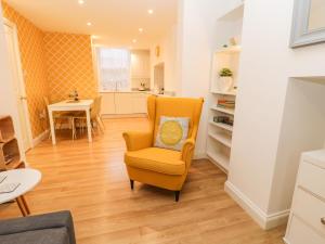 ウィットビーにあるWest Cliff Apartmentのリビングルーム(黄色い椅子、テーブル付)