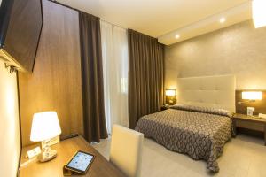 una camera d'albergo con letto, tavolo e scrivania di Hotel Touring a Lido di Jesolo