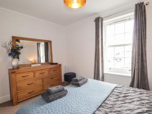 a bedroom with a bed with a dresser and a mirror at The Nook in Inverness