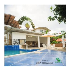 a villa with a swimming pool in front of a house at FINCA VILLA MAGALY en medio de la Naturaleza in Melgar