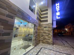 un edificio con una puerta de cristal con un cartel. en Hotel Dubai Suite en Pasto